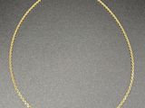 a gold chain necklace with three small beads on a black surface