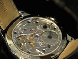 a close up of a watch on a black surface