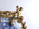 a blue and white vase with a gold decoration on it