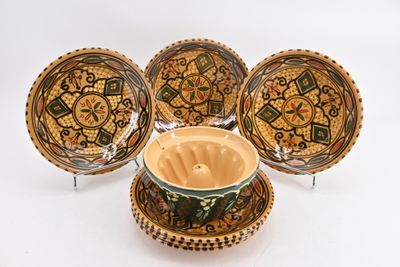 three bowls and a bowl on a stand with a bowl in front of them