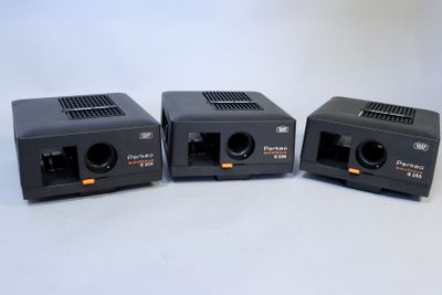 three black cameras sitting side by side on a white surface