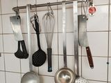 many kitchen utensils hanging on the wall
