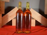 two bottles of wine sitting next to each other on a table