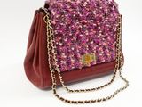 purple and red handbag with chain strap on a white background