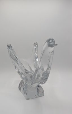 figurine d'oiseau en verre transparent posée sur une surface blanche