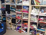 a room filled with lots of clothes and a suitcase