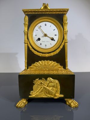 une horloge en or posée sur une table noire