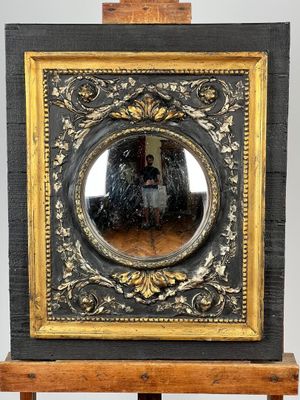 painting of a man and a woman in a mirror on a wooden easel