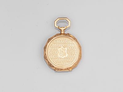 a close up of a gold pocket watch on a white surface