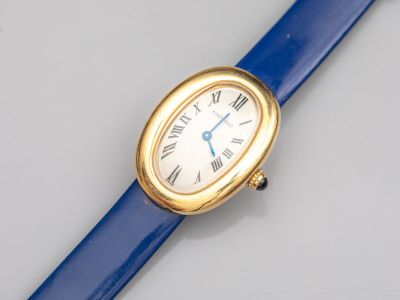 une image représentant une montre-bracelet dorée et bleue avec des chiffres romains