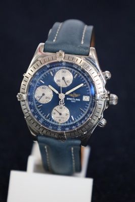 the watch is blue and has a leather strap on it