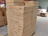 boxes stacked on pallets in a large warehouse with a skylight overhead