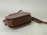 a small brown leather bag with a strap on it