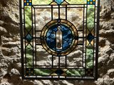 a stained glass window in the corner of a stone wall