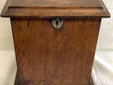 an old wooden box sitting on a white cloth covered surface