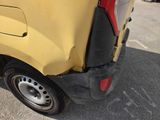 the rear end of a yellow van with a flat tire
