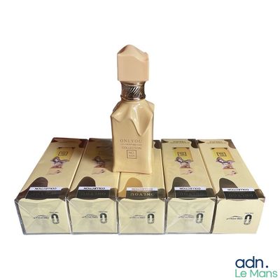 a bottle of perfume sitting on top of a stack of boxes