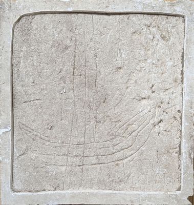 une image représentant une plaque de pierre sur laquelle est sculpté un bateau