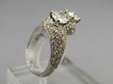 a close up of a diamond ring on a clear surface