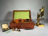 une boîte en bois contenant un microscope et d'autres objets