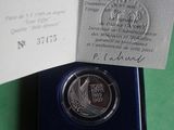 a silver coin in a blue box on a green surface