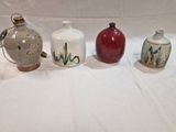 plusieurs vases de styles différents posés sur une surface blanche