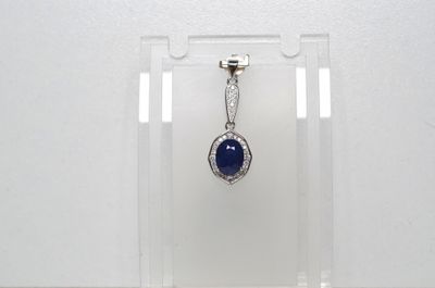 une photo d'un pendentif en pierre bleue et diamants suspendu à un présentoir transparent