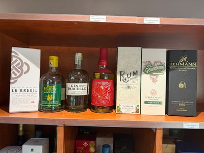 de nombreuses bouteilles d'alcool sur une étagère dans un magasin