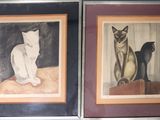 two framed pictures of cats sitting on a table