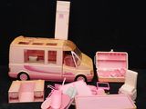 un petit bus rose avec un lit et d'autres objets