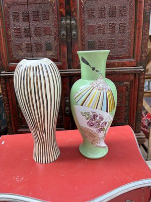 two vases sitting on top of a red table