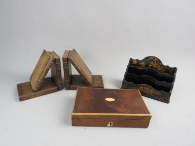 trois petites boîtes en bois et un porte-livre posés sur une surface blanche