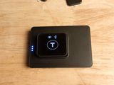 une photo d'un téléphone portable et d'un chargeur posés sur une table en bois