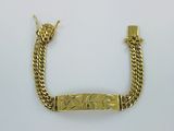un bracelet en or muni d'un fermoir à barre et d'une chaîne