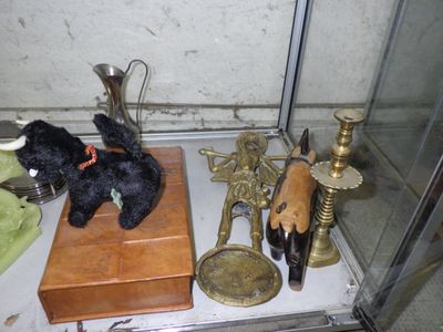 a black teddy bear sitting on top of a table next to other items