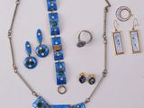 a necklace, earrings, and ring set on a white surface