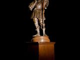 a statue of a man holding a sword on top of a pedestal