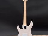 a white electric guitar sitting on top of a wooden table