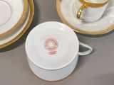 a cup and saucer sitting on a table next to a plate