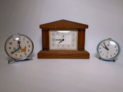 trois horloges posées les unes à côté des autres sur une table