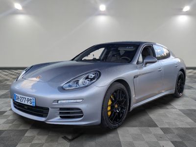 La Porsche Panamera est garée sur un sol en carrelage à damier