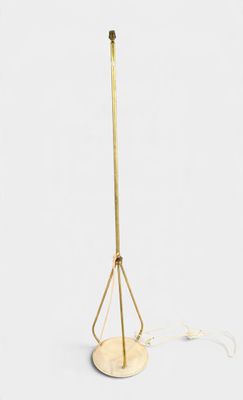 a gold floor lamp with a metal base and a white background