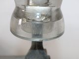 a glass vase with a silver base on a table