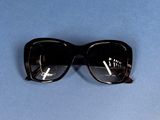 sunglasses on a blue surface with a cigarette sticking out of them