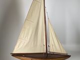 a model of a sailboat on a wooden stand