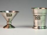 two silver cups sitting next to each other on a table