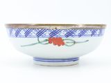 a blue and white bowl with a red flower on it