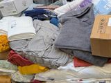 a pile of clothing on the floor next to a box