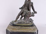 statue en bronze représentant un homme avec un chien, posée sur un socle en marbre