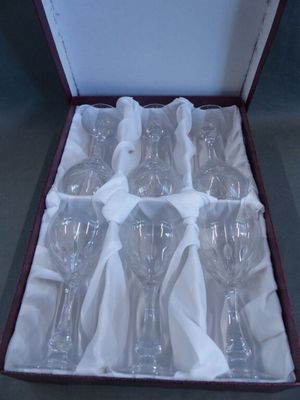 six empty wine glasses in a box on a table